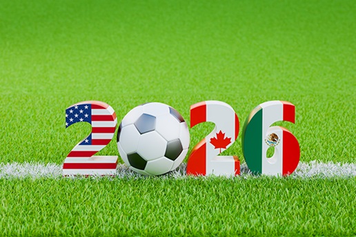 2026 cut out numbers as an American flag, soccer ball, Canadian flag and Mexican flag patterns glaon a football field