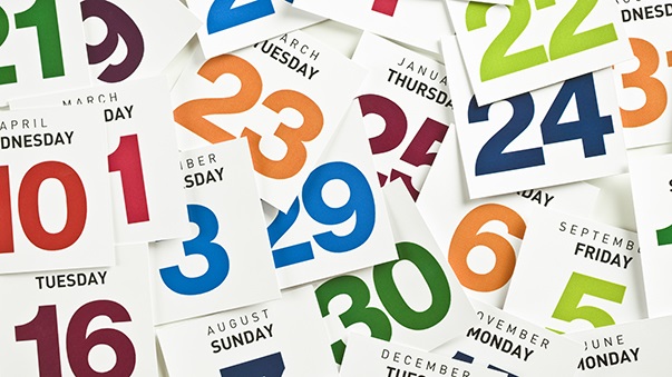 Scattered pages from a calendar with colorful numbers.