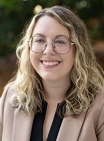 Young woman with long blonde hair and glasses.